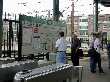 Group awaits inbound trolley, as some check out the transit map